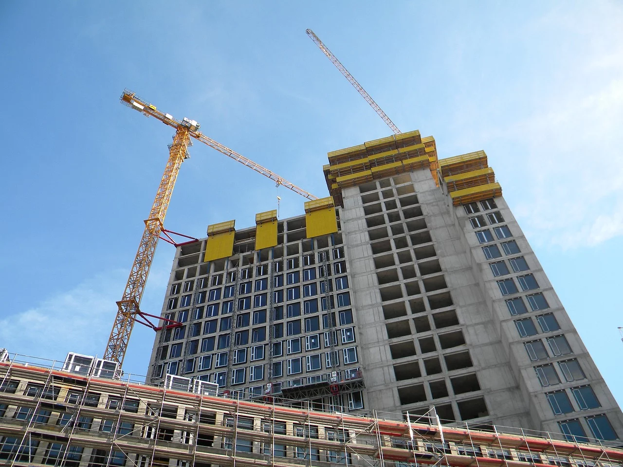 Tall apartment building with 20 stories under construction with crane